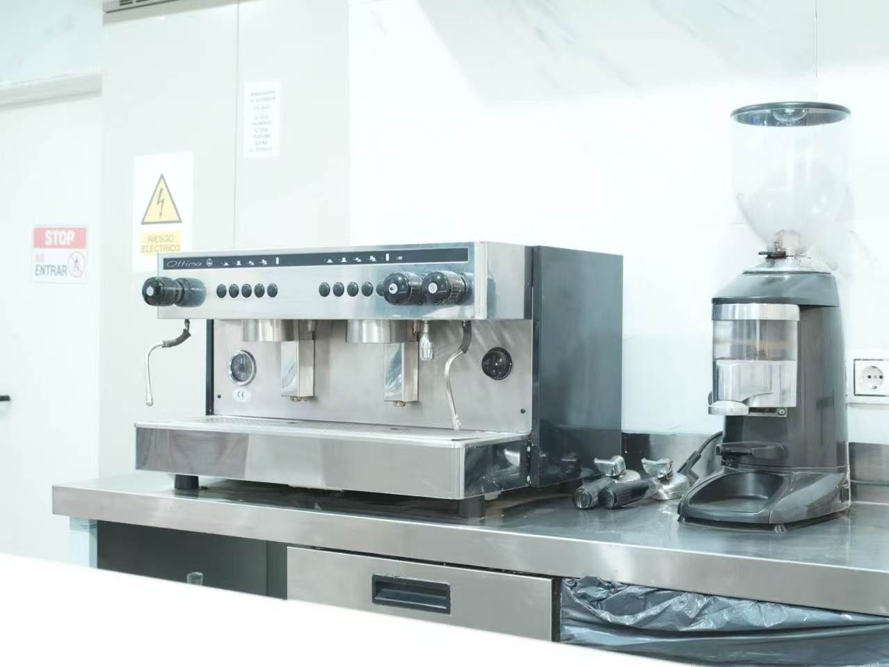 A commercial kitchen with a coffee machine and a large espresso machine.