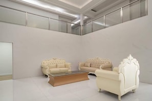 Une pièce spacieuse avec deux canapés de couleur crème et une table basse en verre.
