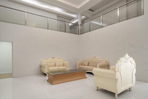 Amplia habitación con dos sofás color crema y una mesa de centro de vidrio.