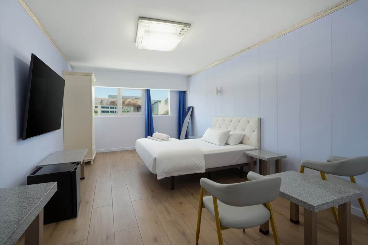 Habitación doble | Escritorio y ropa de cama