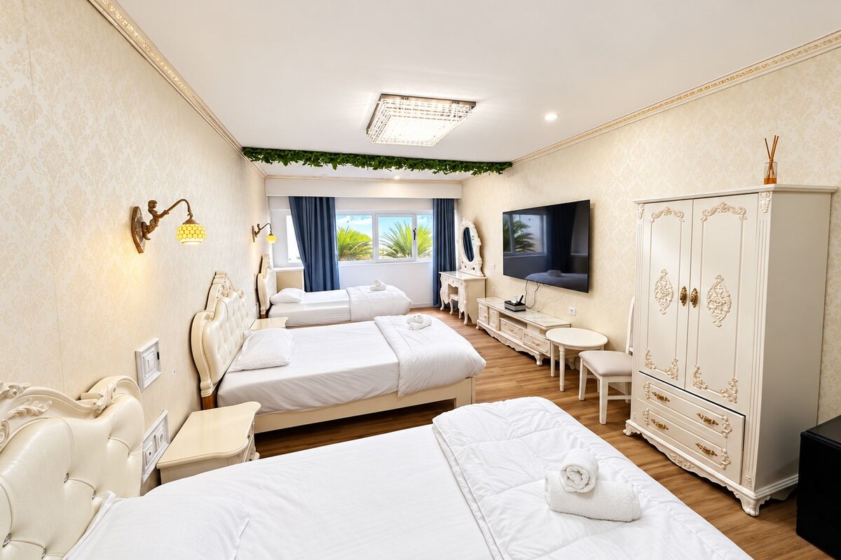 Habitación triple Confort | Escritorio y ropa de cama