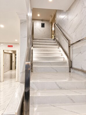 A marble staircase in a hotel lobby with a sign indicating 'No Exit' and a security camera above. - air hotel aviacion  (Manises)