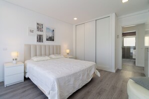A modern bedroom with a large bed, bedside tables with lamps, a wardrobe, and framed pictures on the wall. - Villa with a pool, near Serra da Arrábida and the beaches, Azeitão, Portugal (São Simão)