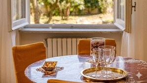 Une table à manger donnant sur un jardin, vue à travers une fenêtre.