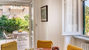 Une table ronde avec un plateau en marbre, deux chaises, un plateau avec des verres et un verre rempli de noix.