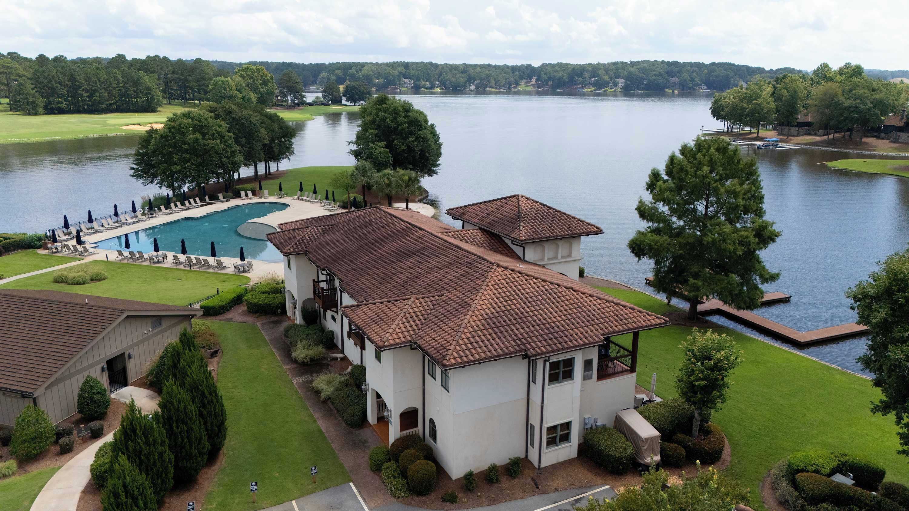 A large building with a swimming pool and a view of a lake.