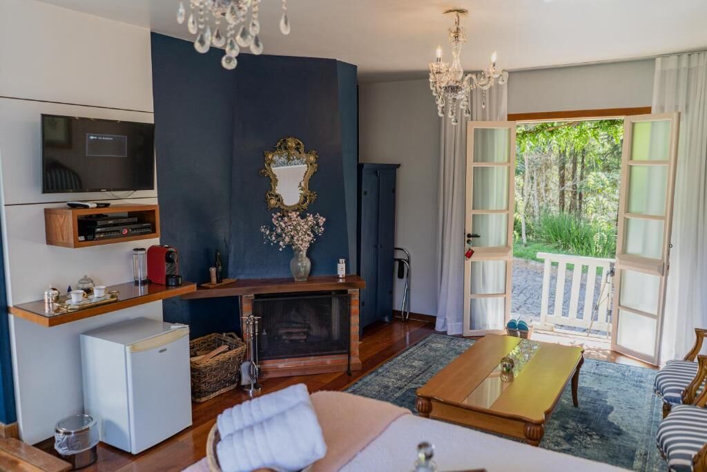 Una habitación moderna con televisión, chimenea, mesa de comedor y vistas al exterior.