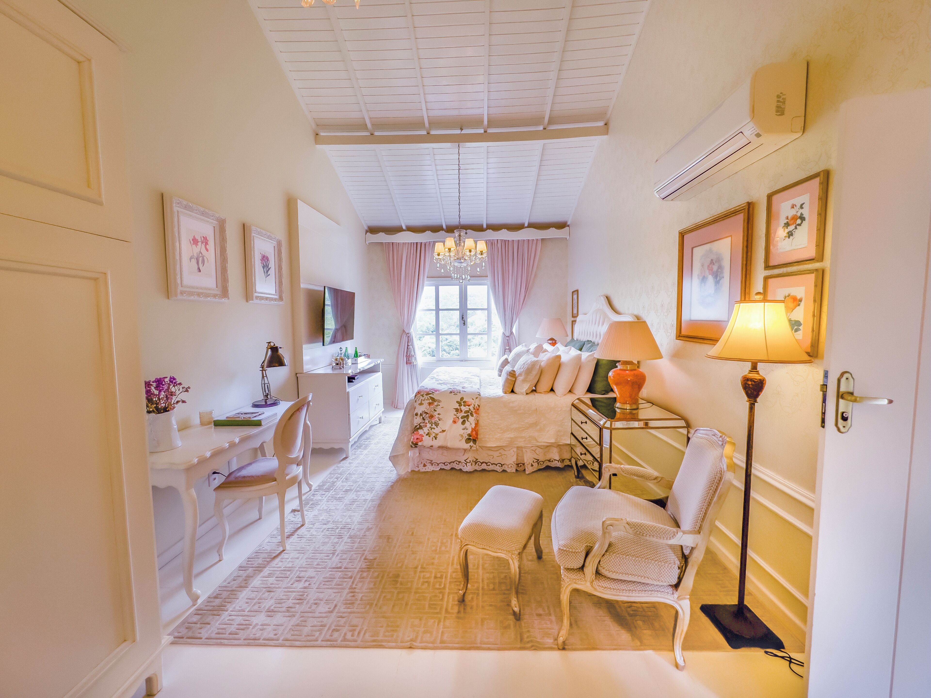 Une pièce bien éclairée, avec un lit, un bureau, une chaise et une lampe.