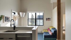 A modern kitchen with a large window, a sink, and a dishwasher. - Owl at the Mill  - 3 (Westport)