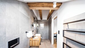 Une salle de bain moderne avec un meuble-lavabo en bois, un miroir et un espace douche.