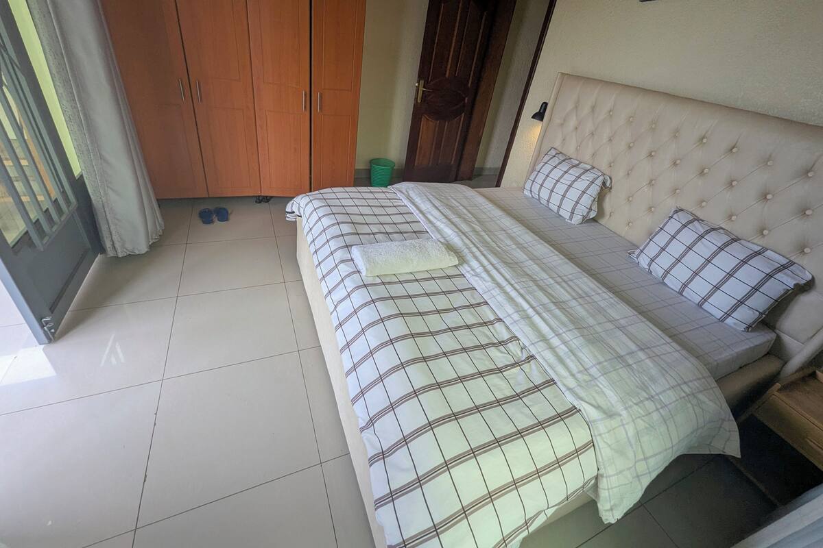 A bedroom with a bed, a wardrobe, and a door.