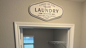 Une buanderie équipée d’un lave-linge, d’un sèche-linge et d’un étendoir à linge.