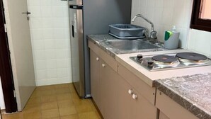 A compact kitchen with a sink, a dish rack, and a stove. - Apartment in the heart of downtown Mendoza. (Mendoza)