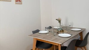 A dining table set with plates, glasses, and a vase with flowers. - Apartment in the heart of downtown Mendoza. (Mendoza)