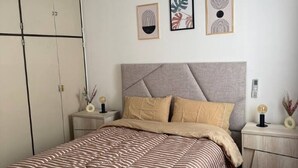 A bedroom with a bed, nightstands, and a wardrobe. - Apartment in the heart of downtown Mendoza. (Mendoza)