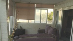 A spacious living area with a large sectional sofa, a white potted plant, and a hexagonal tiled floor.