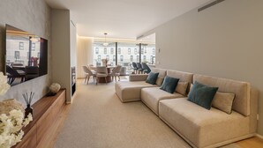 Una sala de estar moderna con un sofá color beige, una mesa de comedor y sillas.