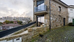 Een gebouw van steen met een modern balkon en een trap naar de ingang.