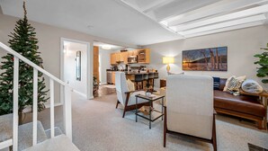 Ein moderner Wohnraum mit Treppe, Essbereich und Küche.