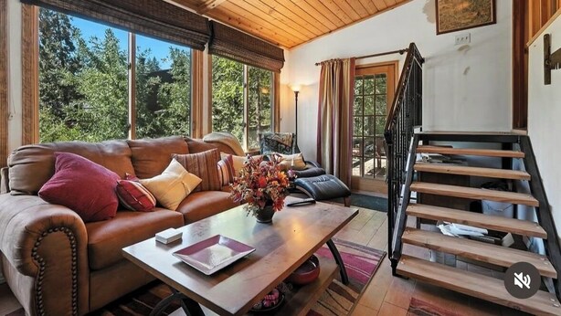 A cozy living room with a leather sofa, a wooden coffee table, and a staircase. - Cozy cabin right at Lewis Creek Trail, near  Yosemite, Bass lake (Oakhurst)