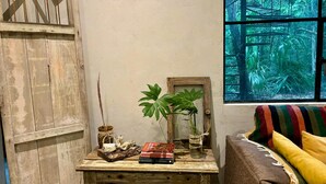 A rustic wooden table with a mirror, a potted plant, and a stack of books. - Beautiful House in the Heart of the Jungle - Yaáxnik (Tulum)