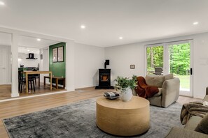 A modern living room with a round wooden coffee table, a beige sofa, and a fireplace.