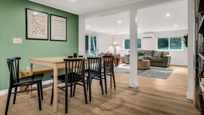 A modern living room with a dining area, a sofa, and a coffee table. - Secluded White Mtns Retreat • Hot Tub • Sleeps 10 • Pet Friendly (Albany)