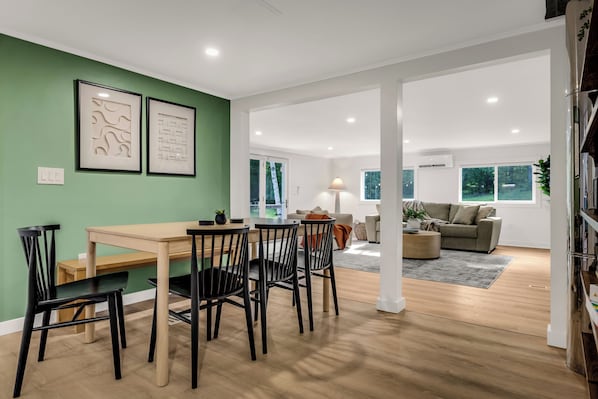 A modern living room with a dining area, a sofa, and a coffee table.