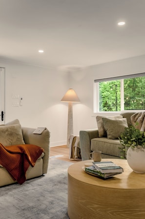 A modern living room with a sofa, a coffee table, and a lamp.