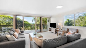 A spacious living room with a balcony, a flat-screen TV, and a comfortable seating area. - Kingfish 1 (PEREGIAN BEACH)