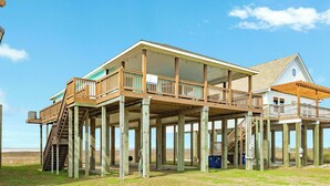 A two-story house with a balcony, wooden deck, and a covered porch.