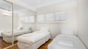 A hotel room with two beds, a large mirror, and a ceiling fan. - Notre Reve 2 Peregian Beach (PEREGIAN BEACH)