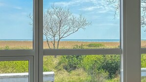 A window with a view of a beach, a tree, and a grassy area. - Amazing home in Hals with house a panoramic view (Hals)