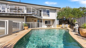 A two-story house with a swimming pool, outdoor furniture, and a fenced balcony. - Brolga Place Noosa Shire (PEREGIAN BEACH)