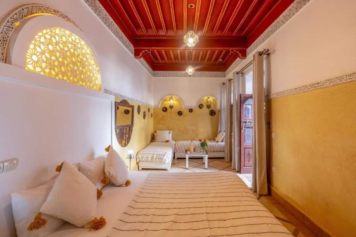 Una habitación de hotel con cama, sofá, una mesita y decoración en la pared.
