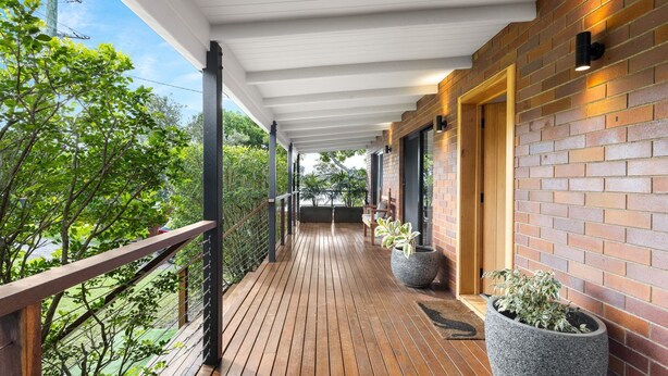 A wooden deck with a white ceiling, brick walls, and potted plants. - Gannet's Nest Peregian Beach (Peregian Beach)