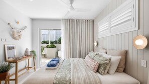 A bedroom with a bed, bedside table, and a view of the outdoors. - Olas by The Sea 2 Peregian Beach (Peregian Beach)