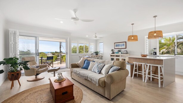 A modern living room with a sofa, coffee table, and a view of the outdoors. - Sunbright 1 Peregian Beach (Peregian Beach)