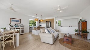 A modern living space with a dining area, kitchen, and seating area. - Sunbright 1 Peregian Beach (Peregian Beach)