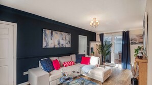 Ein modernes Wohnzimmer mit einer Couch, einem Couchtisch und einem großen abstrakten Gemälde.