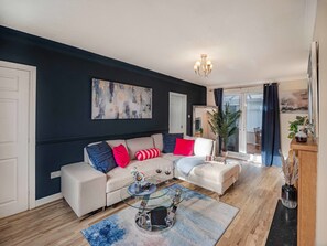 Ein modernes Wohnzimmer mit einer Couch, einem Couchtisch und einem großen abstrakten Gemälde.