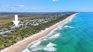 An aerial view of a coastal area with a beachfront property, including houses and a beach. - Blue Horizon Peregian (Peregian Beach)