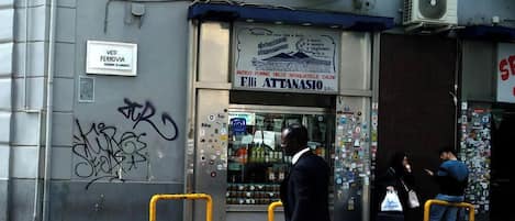 A storefront with a sign for 'Eli Attanasio S.R.L.' and a window displaying various products.