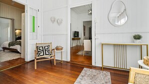 A spacious living area with a wooden floor, a dining table, and a sofa. - Wandal Haven • 3BR • King • + 2 Doubles • Pets OK (Rockhampton)