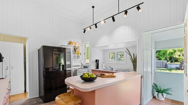 A modern kitchen with a central island, built-in appliances, and a view to the outdoors. - Wandal Haven • 3BR • King • + 2 Doubles • Pets OK (Rockhampton)