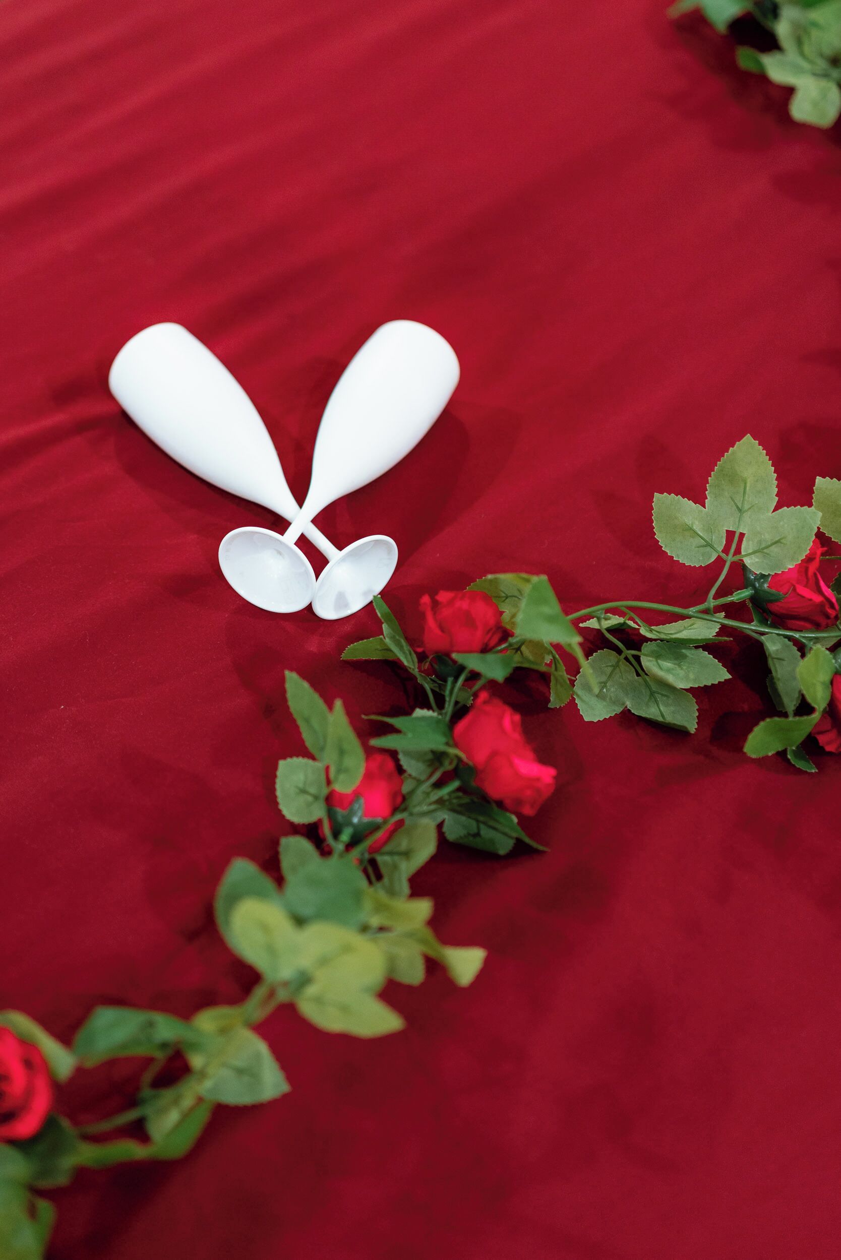 A red fabric background with white objects and red roses.