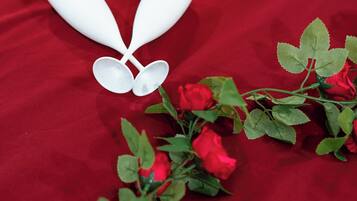 A red fabric background with white objects and red roses.