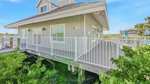 Ein Küstenhaus mit Terrasse, überdachter Veranda und Meerblick.