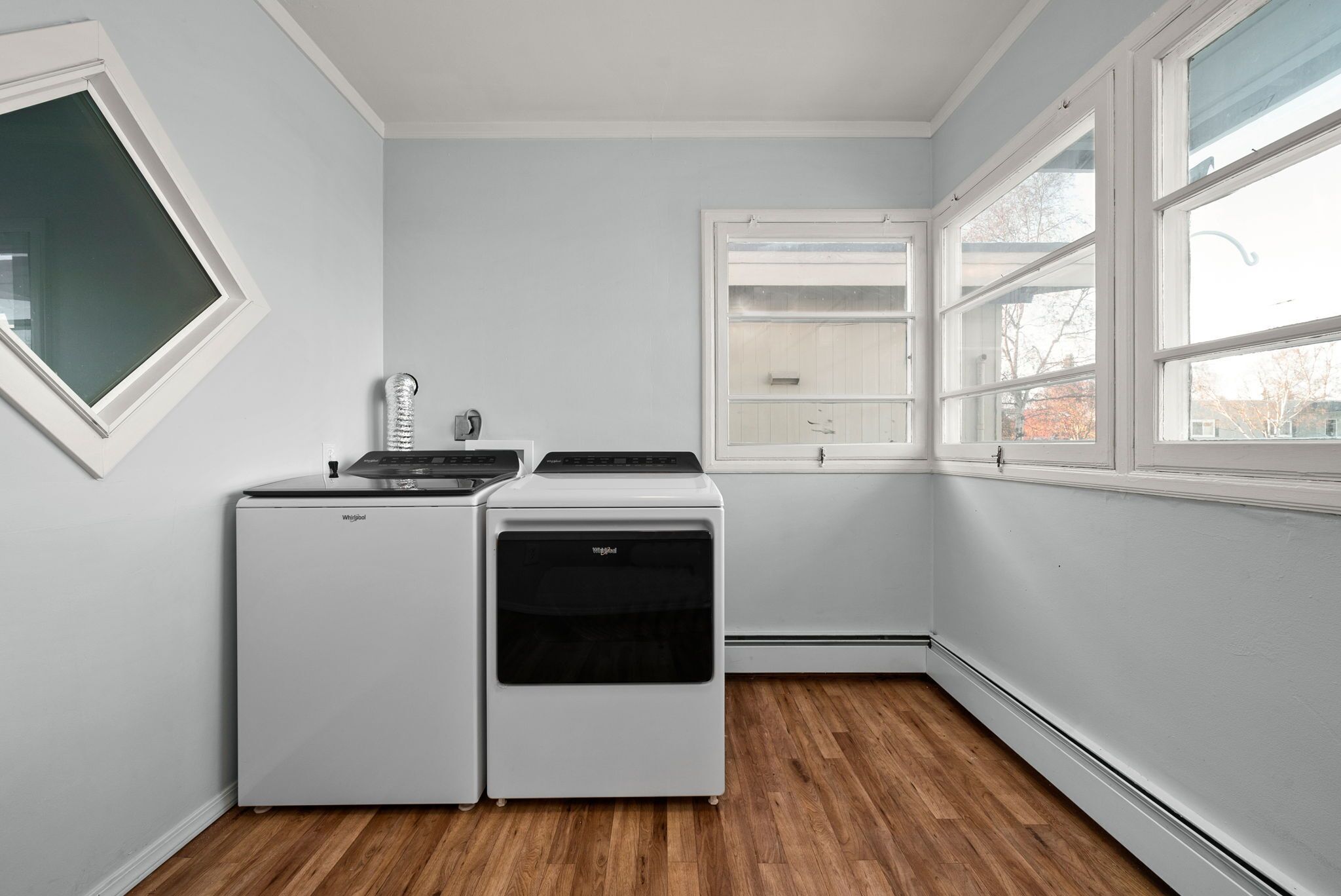 Eine kompakte Küche mit Kühlschrank, Herd und Backofen. Ein Fenster bietet Blick ins Freie.