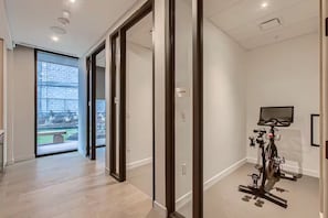 Ein modernes Interieur mit einem Fahrrad in der Ecke, einem großen Fenster und einer Tür, die nach draußen führt.